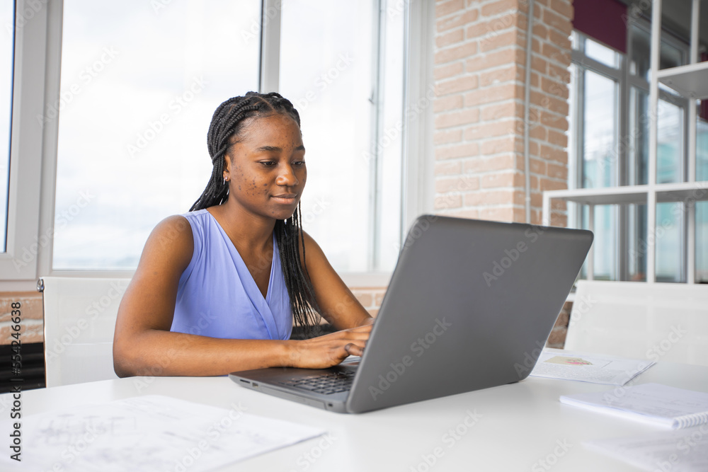 beautiful african woman working on laptop in office beautiful african woman working on laptop in office