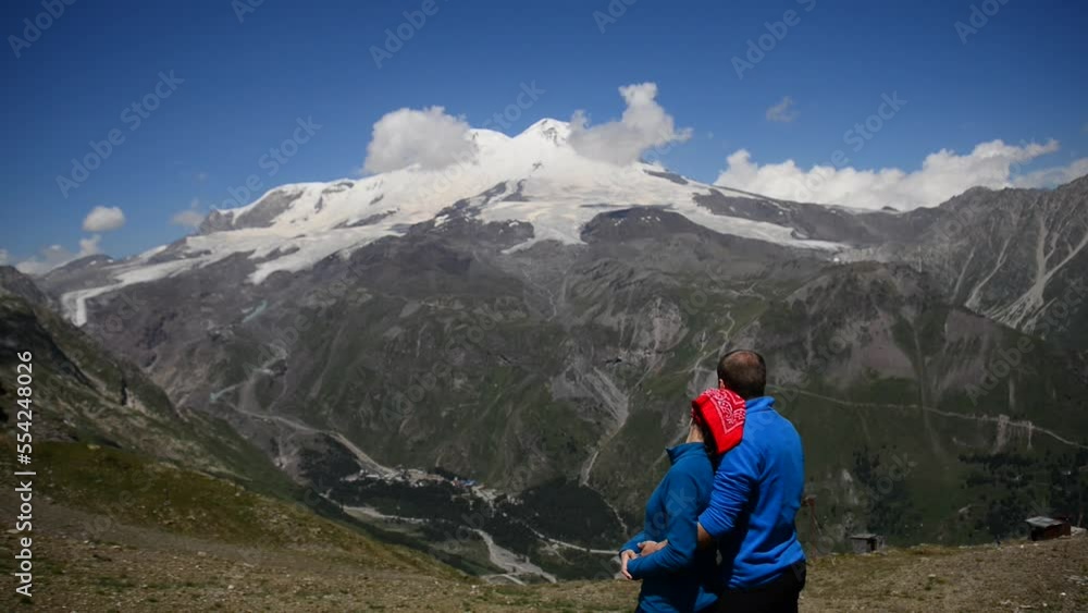 the couple is hugging and looking at Elbrus the couple is hugging and looking at Elbrus