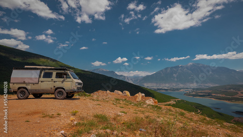 Adventure oldtimer van or camper, campervan on high plain with good view panorama of city Kukes in albania on a summer day. Albanian roadtrip with vintage campervan photo