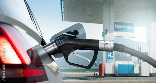 Close up of fuel cell car with connected hydrogen fueling nozzle on a background of H2 filling station . Clean mobility concept