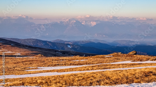 Scenic view of snow covered alpine meadows and Karawanks mountains seen from Ladinger Spitz, Saualpe, Lavanttal Alps, Carinthia, Austria, Europe. Hiking trails at morning golden hour, Wolfsberg region photo