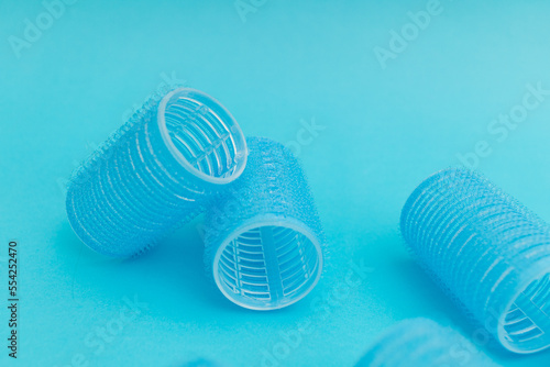 Large hair curlers on blue background  monochrome