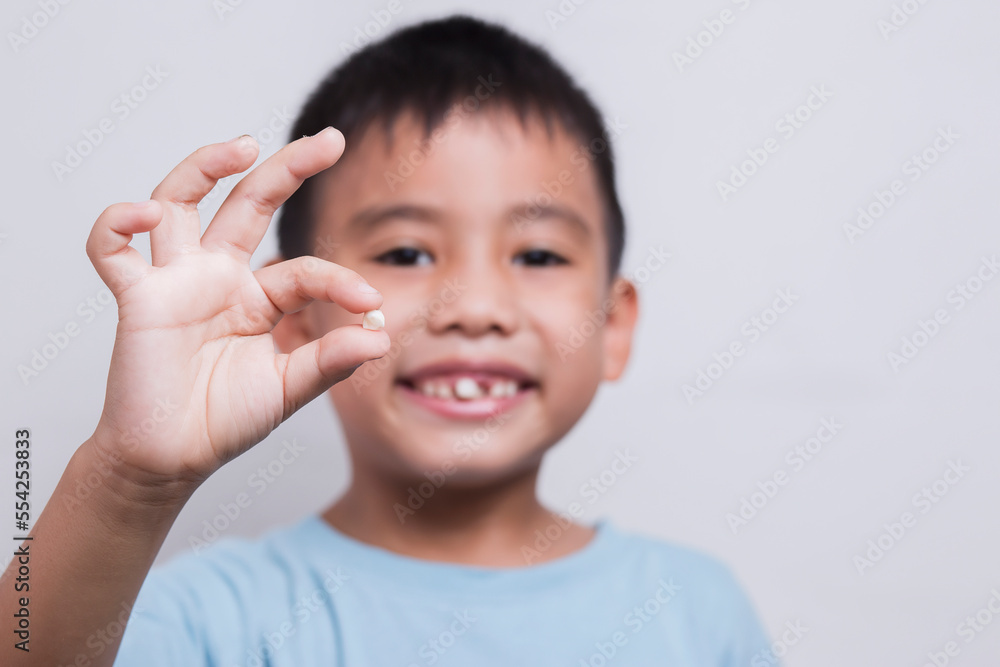 boy face looking at tooth and showing teeth behind on white background. boy face looking at tooth and showing teeth behind on white background.