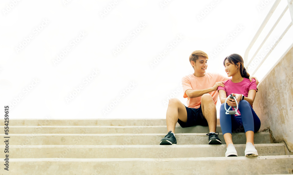 Soul mate, close friend, young asian couple, sitting comfortably at the stairs of the stadium after exercising, playing sports, relaxing with a friendly massage to relieve aching shoulder muscles.