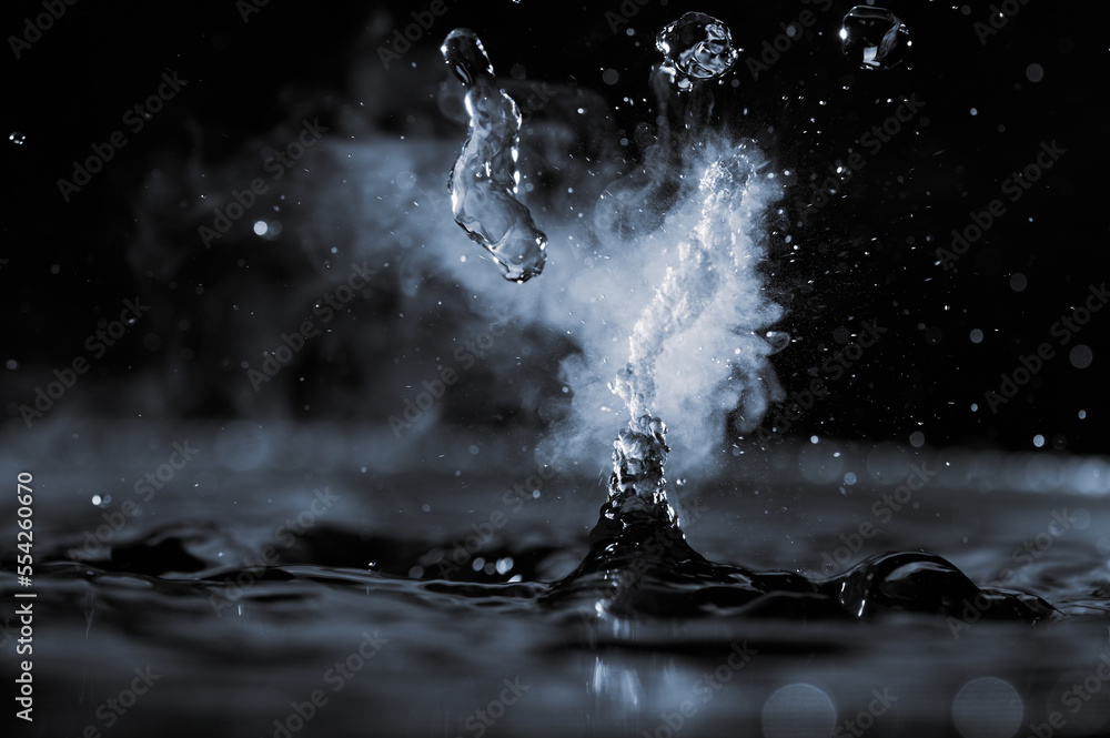 Boiling water splash with steam on black background closeup Stock Photo