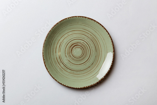 Fototapeta Naklejka Na Ścianę i Meble -  Top view of isolated of colored background empty round green plate for food. Empty dish with space for your design