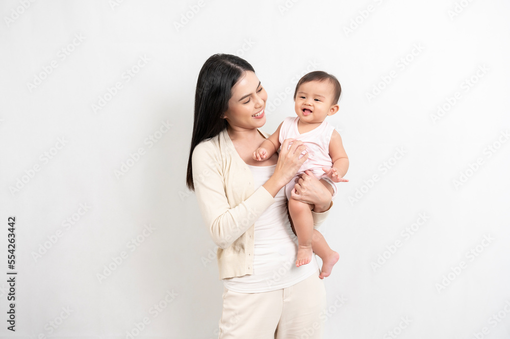 Beautiful mother and adorable baby girl are happy on white background, family, child, childhood and parenthood concept Beautiful mother and adorable baby girl are happy on white background, family, child, childhood and parenthood concept