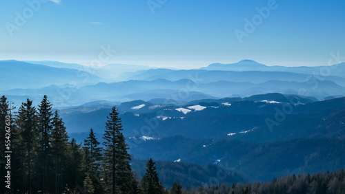 Scenic view of alpine meadows, high altitude forest and hills seen from hiking trail to Ladinger Spitz, Saualpe, Lavanttal Alps, Carinthia, Austria, Europe. Karawanks mountain range in the background © Chris