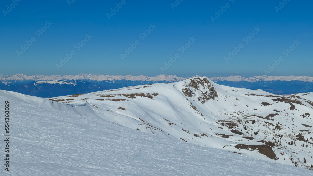 Scenic view of snow covered alpine hills on hiking trail from Ladinger Spitz to Gertrusk, Saualpe, Lavanttal Alps, Carinthia, Austria, Europe. Untouched field of snow. Ski touring snowshoeing tourism