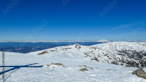 Scenic view of snow covered alpine hills on hiking trail from Ladinger Spitz to Gertrusk, Saualpe, Lavanttal Alps, Carinthia, Austria, Europe. Untouched field of snow. Ski touring snowshoeing tourism