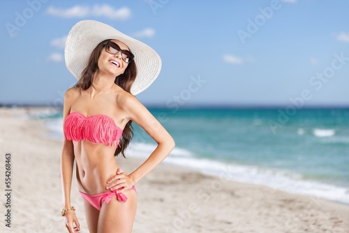 Happy woman wear swimsuit, walk on beach