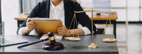 Fotografia law books and scales of justice on desk in library of law firm