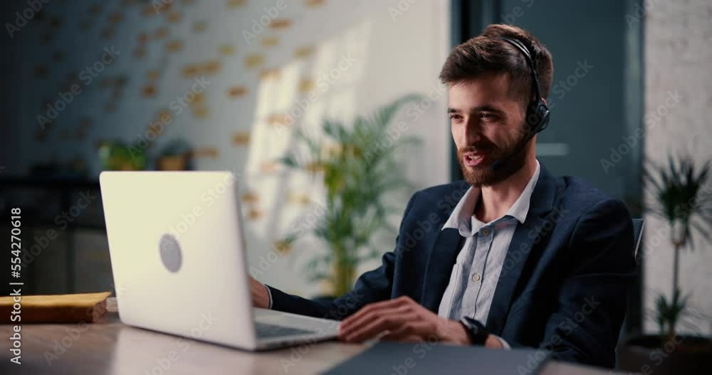Male manager of online store is at business video meeting with representatives of another trading platform and agrees on cooperation. Young man with beard communicates in friendly way on a video call. Male manager of online store is at business video meeting with representatives of another trading platform and agrees on cooperation. Young man with beard communicates in friendly way on a video call.