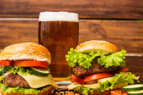 Burgers and beer on wooden background