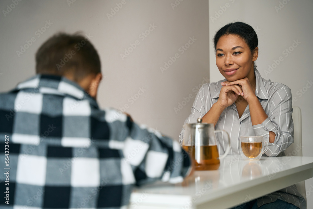 Pretty elegant female is sitting at the table in the kitchen Pretty elegant female is sitting at the table in the kitchen