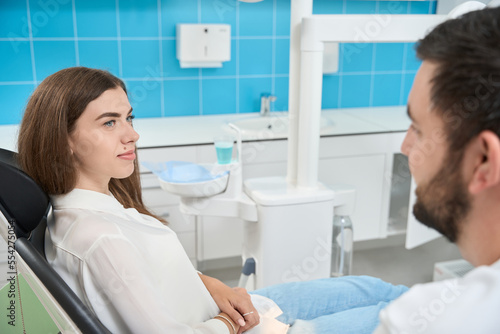Female client consulting professional dentist during appointment