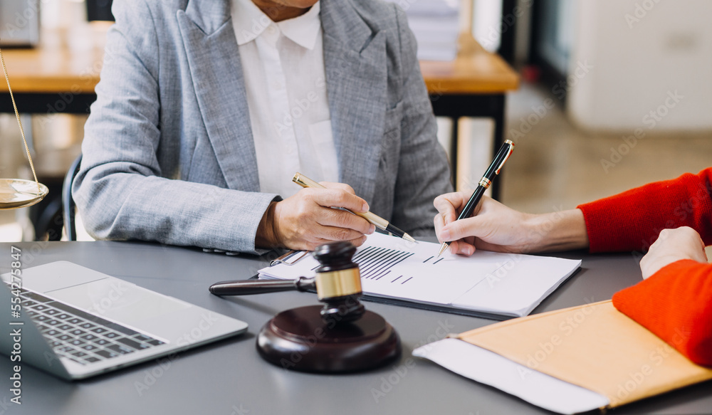 Business and lawyers discussing contract papers with brass scale on desk in office. Law, legal services, advice, justice and law concept picture with film grain effect Business and lawyers discussing contract papers with brass scale on desk in office. Law, legal services, advice, justice and law concept picture with film grain effect