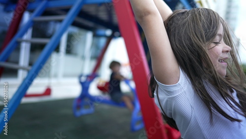 Schilderij op canvas Small girl holding into metal bar at playground child hand holds on monkey bar