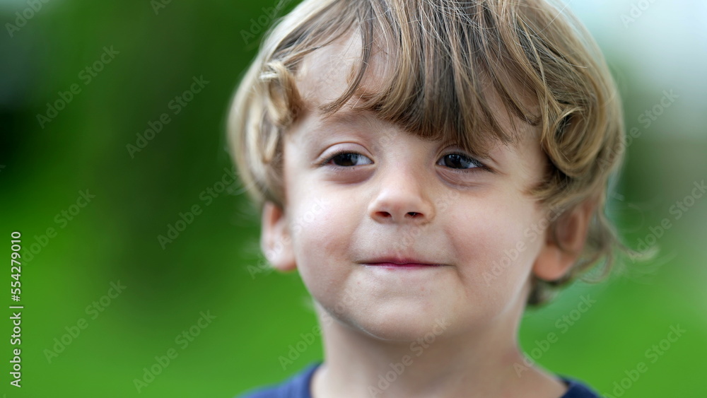 Adorable child portrait smiling at camera little boy face closeup smiles outside at park Adorable child portrait smiling at camera little boy face closeup smiles outside at park