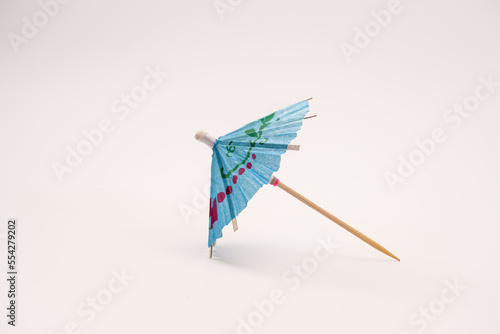 Single blue cocktail parasol umbrella isolated on a white background side view photo
