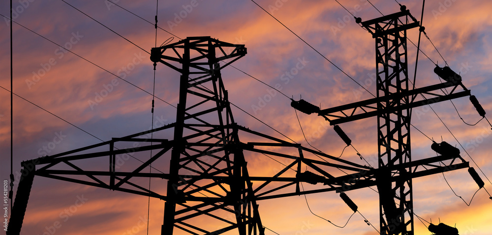 Electricity pylon (high voltage power line), black contour,  against the background of a romantic evening sky