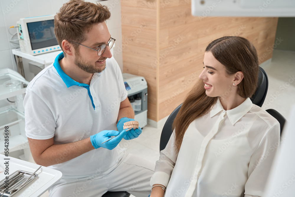 Obraz premium Dental hygienist telling about interdental plaque to client