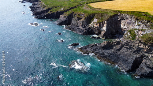 Seaside landscape of the south of Ireland. Picturesque coastal cliffs. The water of the Atlantic Ocean is turquoise.