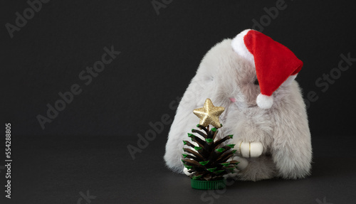 Wallpaper Mural Toy gray bunny in santa hat with Christmas tree made of pine cone on dark background with space for your text Torontodigital.ca