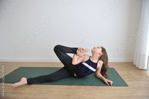 menina fazendo exercicios físicos e mentais em casa alongamento e pose