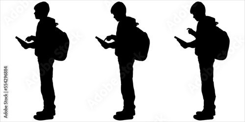 School student with a backpack, and a phone. Young teenagers scroll through smartphones. Teenagers use mobile cell phones together. Communicating online. Gadget addiction, communication technology