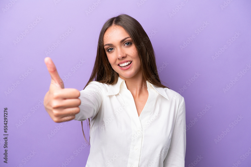 Young caucasian woman isolated on purple background with thumbs up because something good has happened Young caucasian woman isolated on purple background with thumbs up because something good has happened
