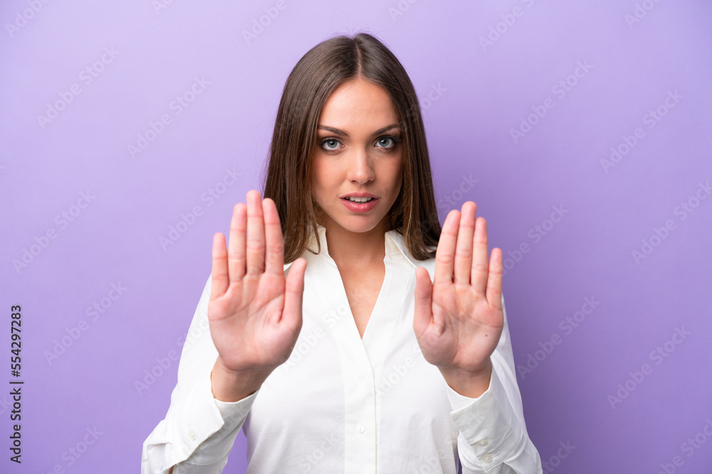Young caucasian woman isolated on purple background making stop gesture and disappointed Young caucasian woman isolated on purple background making stop gesture and disappointed