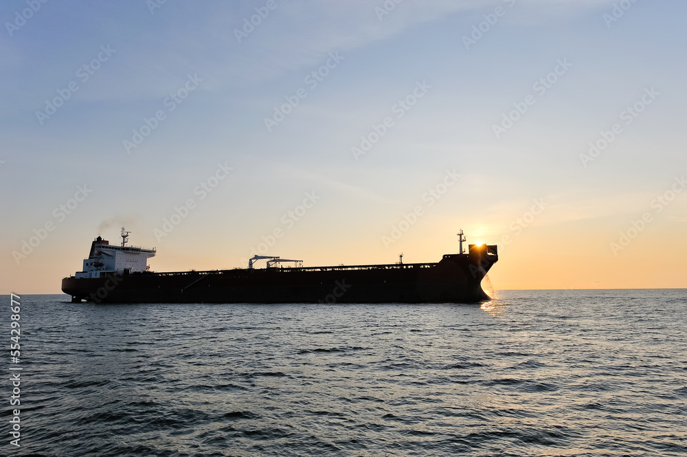 Crude oil tanker in the sea at sunset.
