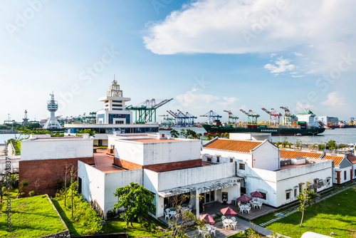 Building view of Hongmaogang Cultural Park in Kaohsiung, Taiwan. In the background are container yards and crane equipment at the Port of Kaohsiung.