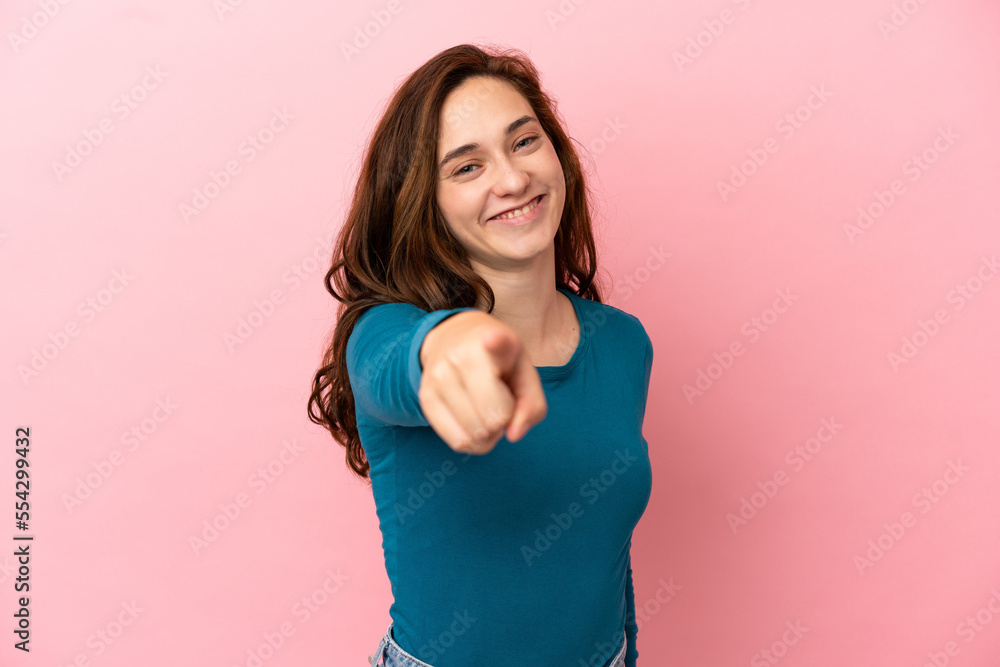 Young caucasian woman isolated on pink background pointing front with happy expression Young caucasian woman isolated on pink background pointing front with happy expression