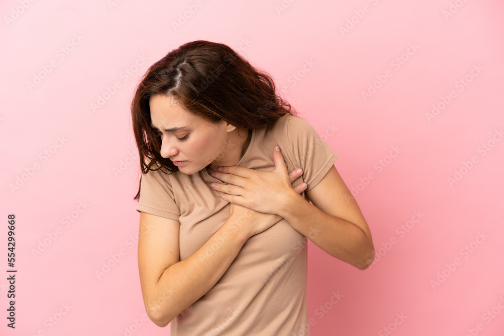 Young caucasian woman isolated on pink background having a pain in the heart Young caucasian woman isolated on pink background having a pain in the heart