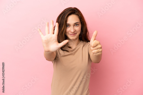 Young caucasian woman isolated on pink background counting six with fingers © luismolinero