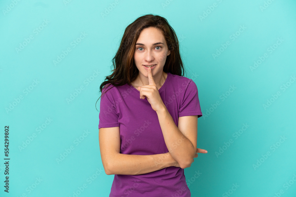 Young caucasian woman isolated on blue background showing a sign of silence gesture putting finger in mouth Young caucasian woman isolated on blue background showing a sign of silence gesture putting finger in mouth