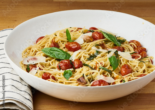 Spaghetti with cherry tomatoes, basil, and shaved parmesan.