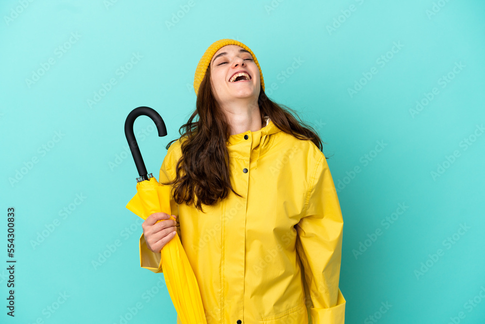 Young caucasian man holding an umbrella isolated on blue background laughing Young caucasian man holding an umbrella isolated on blue background laughing
