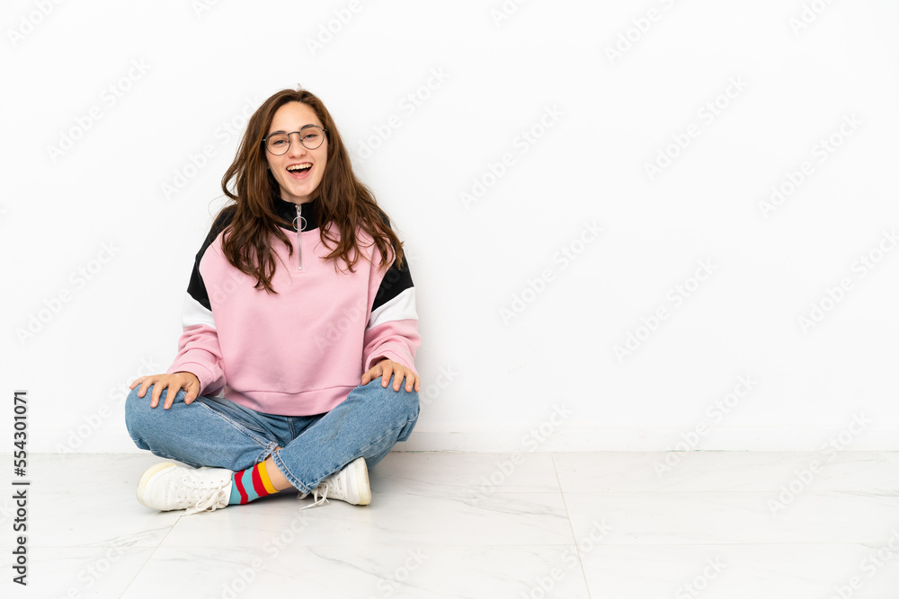 Young caucasian woman sitting on the floor isolated on white background with surprise facial expression Young caucasian woman sitting on the floor isolated on white background with surprise facial expression