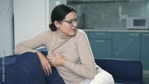 Unhappy brunette woman feeling pain in her breast, mammary gland inflammation photo