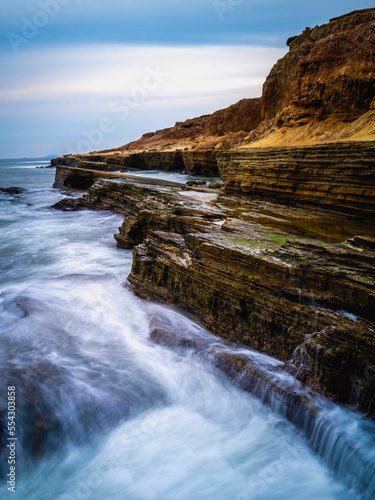 San Diego Seascape Series, dramatic cloudscape with stormy white seafoam splashing to the cliff at Sunset Cliffs in Cabrillo National Monument, Southern California, USA