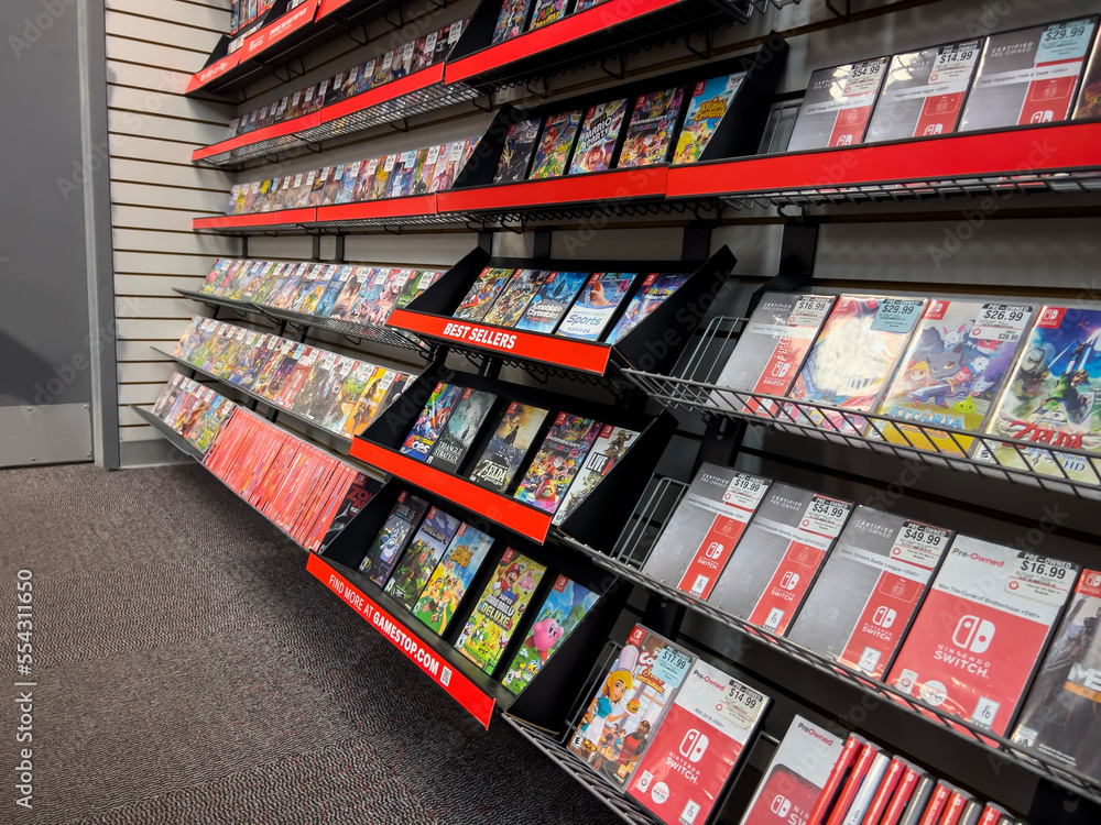 Naklejka premium Seattle, WA USA - circa December 2022: Selective focus on used video games for sale inside a GameStop gaming store.