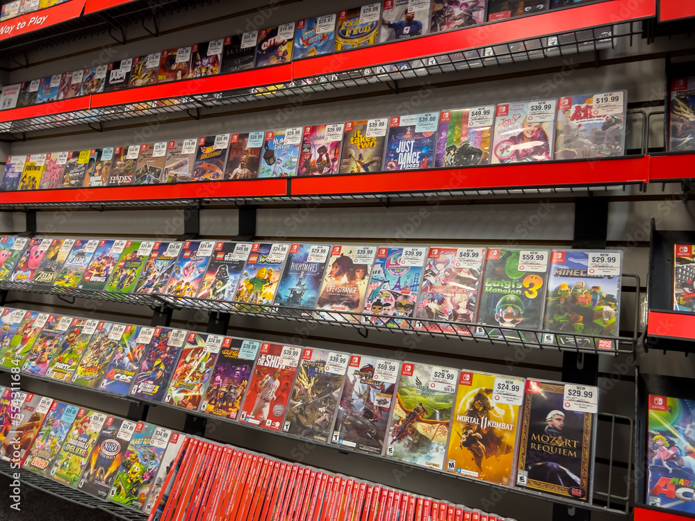Fototapeta premium Seattle, WA USA - circa December 2022: Selective focus on used video games for sale inside a GameStop gaming store.
