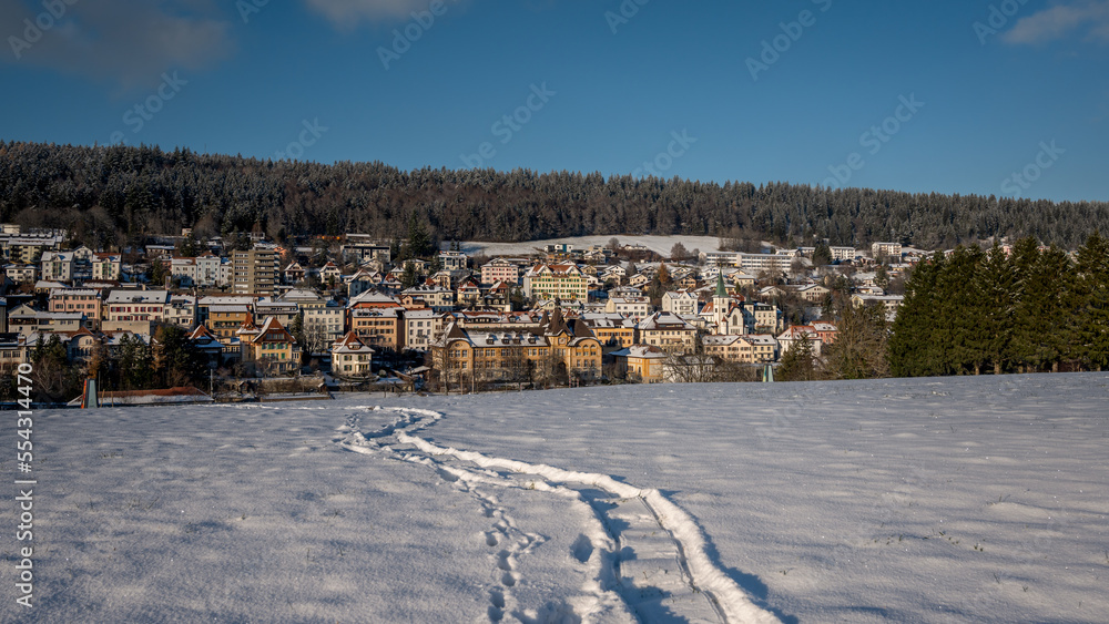Obraz premium Winter landscape with snow. Tramelan village in sunny day. Bern Canton, Switzerland.