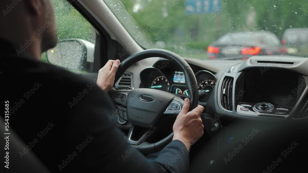 Man drives a car along the road in the city during the rain. Man drives a car along the road in the city during the rain.