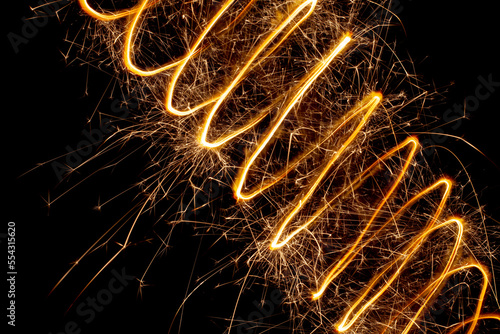 A spiral of light with sparks on a black background. Abstract sparks of fireworks.