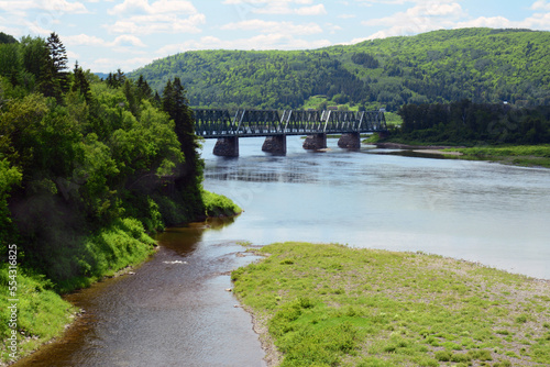 The J.C. Van Horne Bridge, joins New Brunswick, left, to Quebec on the right.; Pointe a la Croix, Metapediac River, Campbellton, New Brunswick, Quebec, Canada. photo