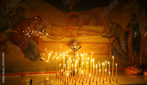 Funeral service, funeral liturgy in the Orthodox Church. Christians light candles in front of the Orthodox cross with the crucifix, the concept of Orthodox faith and religion.
